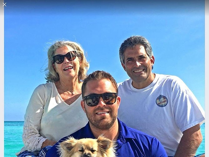 Nikolai Sarles (center), with his parents James and Marina Sarles.