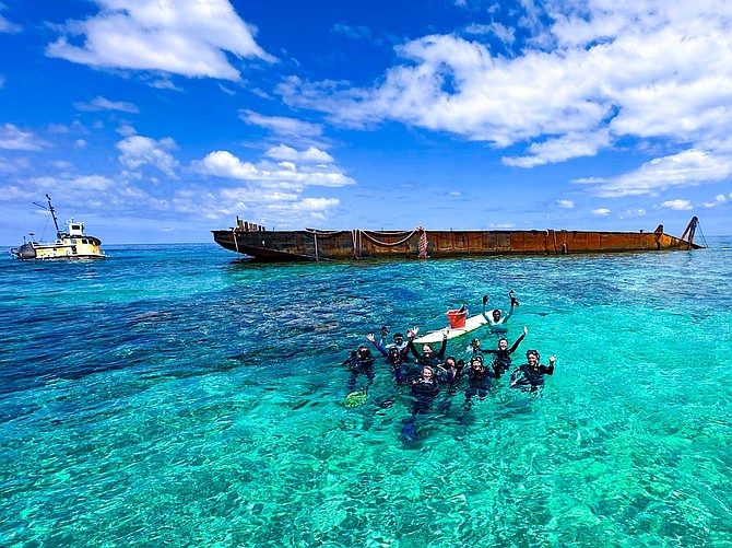 Volunteers team up with Perry Institute for Marine Science to clean Fowl Cay reef where a barge and tug remain a year after stranding.