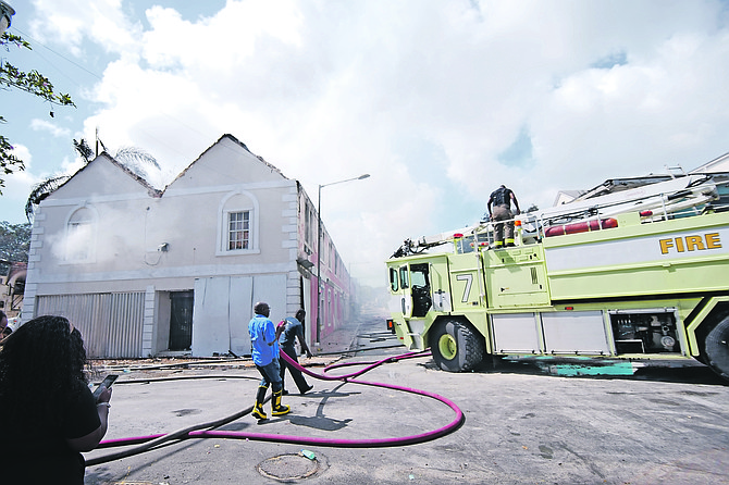 Firefighters continue to mop up of smouldering buildings on Friday after fire destroyed four buildings at Bay and Elizabeth Street. Photos: Chappell Whyms Jr