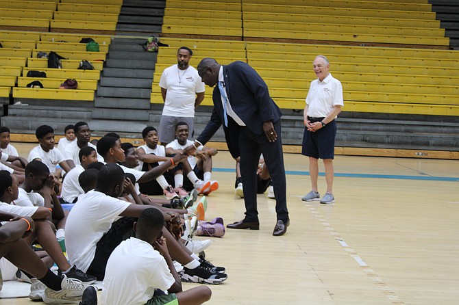 Minister of Youth, Sports and Culture Mario Bowleg interacts with the youngsters yesterday on day two of the Basketball Smiles camp at Kendal Isaacs Gym. Photo: Jonathan Burrows