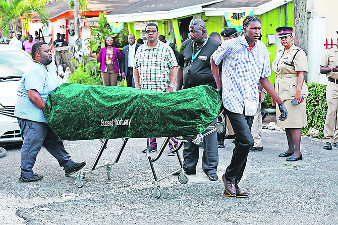 A body is taken from the scene of a murder yesterday. 
Photo: Dante Carrer/Tribune Staff