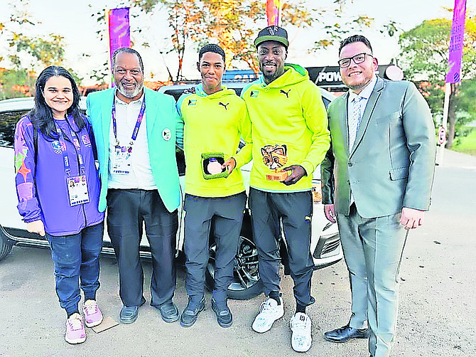 Xavion Johnson displaying his medal with team officials, including federation president D’Arcy Rahming Sr and coach Joshua White.