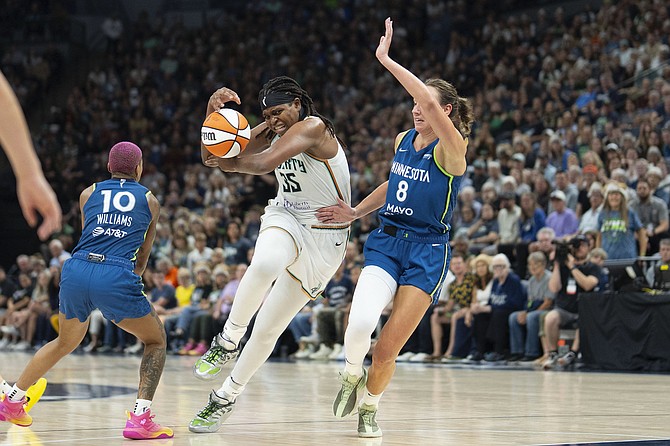 New York Liberty centre Jonquel Jones (35) loses control of the ball as she attempts to drive between Minnesota Lynx guard Courtney Williams (10) and Minnesota Lynx forward Alanna Smith (8) in the fourth quarter of a WNBA basketball game on Saturday, August 16, 2025, in Minneapolis. (Alex Kormann/Star Tribune via AP)