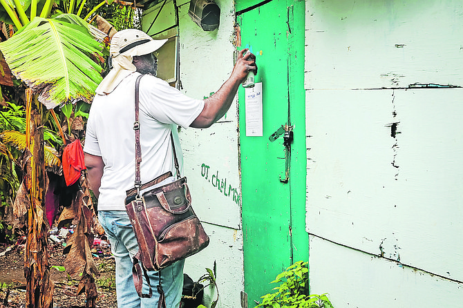 A government official places an eviction notice on a structure in a shanty town in Andros in early September 2025.