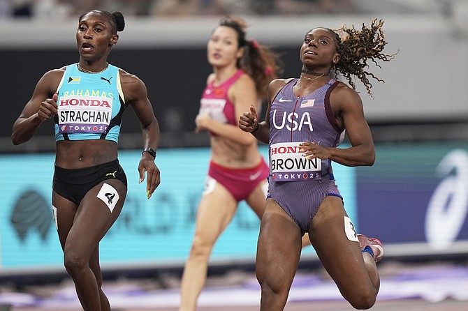 Bahamas' Anthonique Strachan (left) and United States' Brittany Brown compete in women's 200 meters heat at the World Athletics Championships in Tokyo on September 17, 2025. (AP Photo/Eugene Hoshiko)
