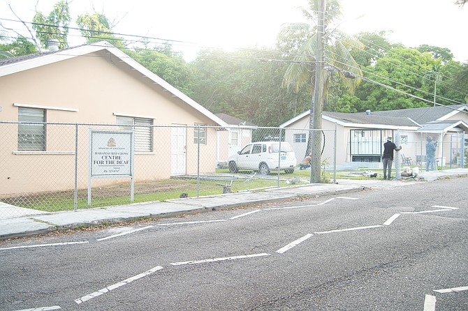 A worker seen repairing a fence at the Centre for the Deaf after thieves broke in, casuing damages and then stealing the school’s bus which they later crashed. Photo: Chappell Whyms Jr