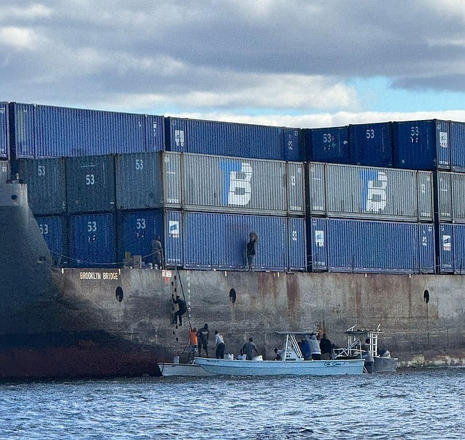 Scores of boats tie up alongside stranded container barge raiding the vessel of its cargo in North Abaco on November 13, 2025.
