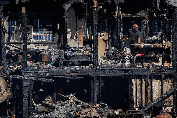 A man is seen in a fire ravaged structure as workers demolish the charred remnants of several establishments the day after they were ravaged by a fire at Arawak Cay’s Fish Fry on November 16, 2025. Photo: Dante Carrer/Tribune Staff