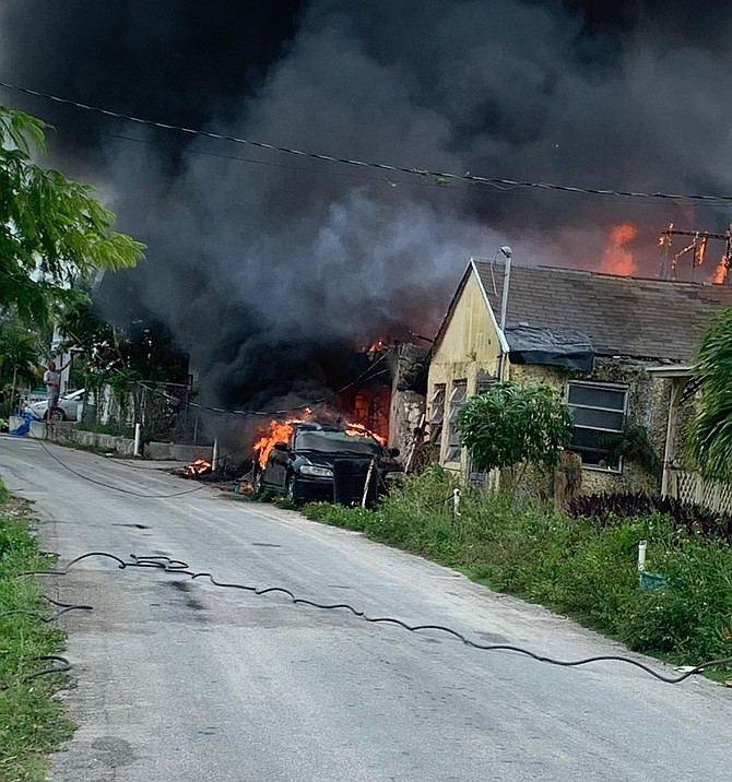 NEIGHBOURS AND VOLUNTEERS work to control the flames as a house on Current, Eleuthera burns down on December 15, 2025.