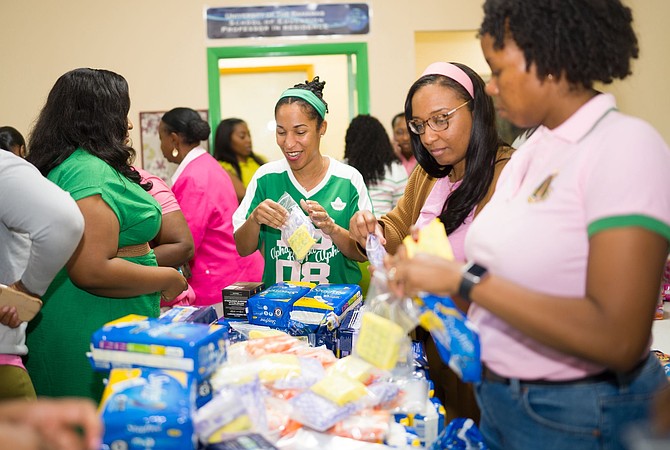MEMBERS of the Eta Psi Omega Chapter of Alpha Kappa Alpha Sorority, Incorporated, pack feminine hygiene kits during a weekend assembly session at TG Glover’s Professional Development and Research Centre.
