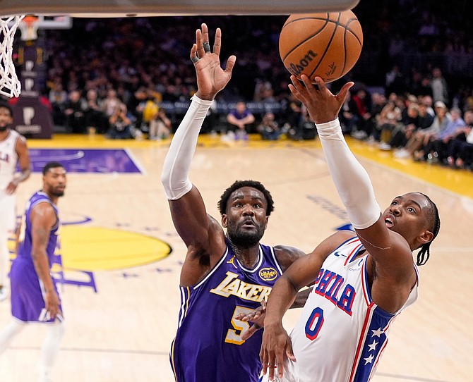 Philadelphia 76ers guard Tyrese Maxey, right, shoots as Los Angeles Lakers center Deandre Ayton defends during the second half of an NBA basketball game Thursday, Feb. 5, 2026, in Los Angeles. (AP Photo/Mark J. Terrill)