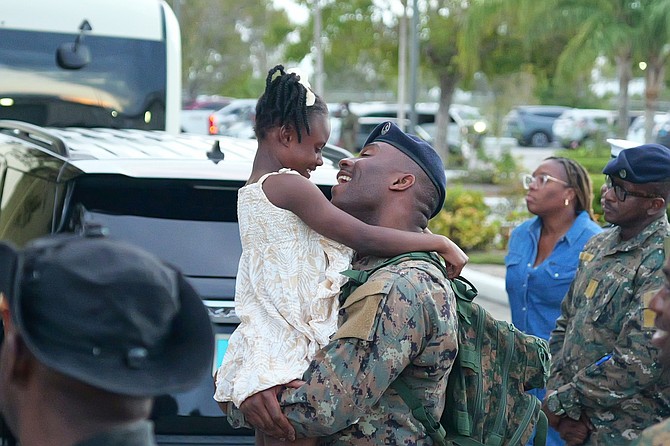 A RBDF marine receives a hug from a young girl after returning
from a deployment to Haiti on March 13, 2026. Photo: Nikia Charlton