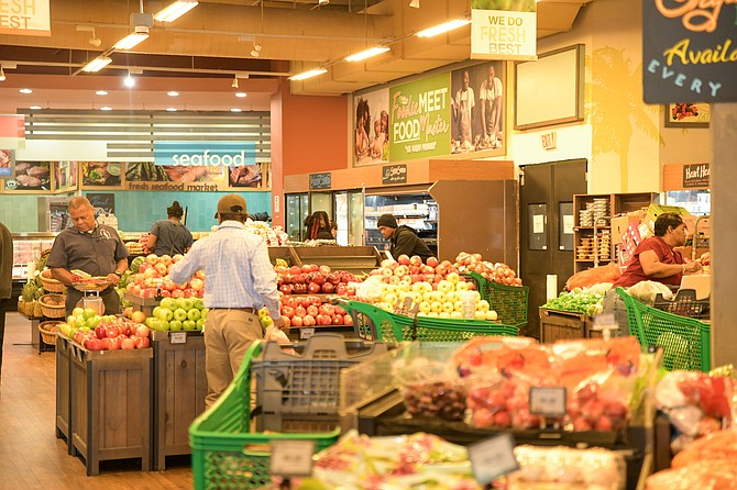 SHOPPERS search for items at Harbour Bay Fresh Market hoping to find lower prices at the start of the VAT elimination on unprepared food items. Photos: Shawn Hanna