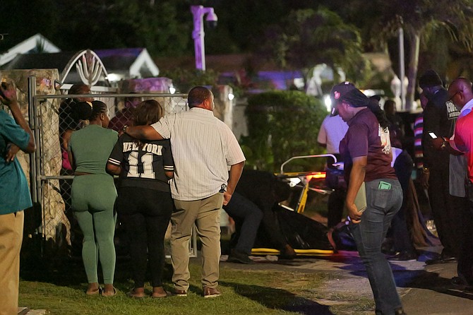 THE BODY of a man shot and killed in an ambush outside his home in the
Mount Pleasant area is removed from the scene last night. Photo: Chappell Whyms Jr
