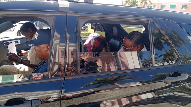 SENIOR Customs officer Pamela Williams covers her head as she leaves court in Grand Bahama on May 19, 2026. Photo: Denise Maycock/Tribune Freeport Reporter