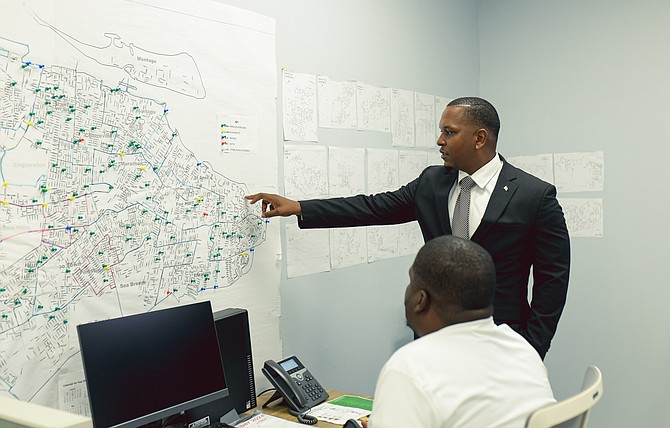Public Parks and Beaches Authority executive chairman Jamahl Strachan looks at a map showing parks and beaches in the New Providence region yesterday. Photo: Shawn Hanna