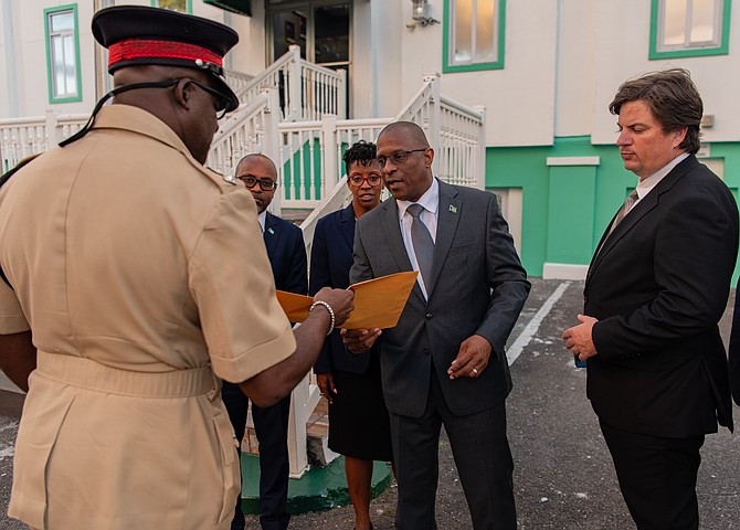 Opposition Leader Michael Pintard, flanked by opposition members, delivers a criminal complaint to police headquarters. Photo: Orion Bethell