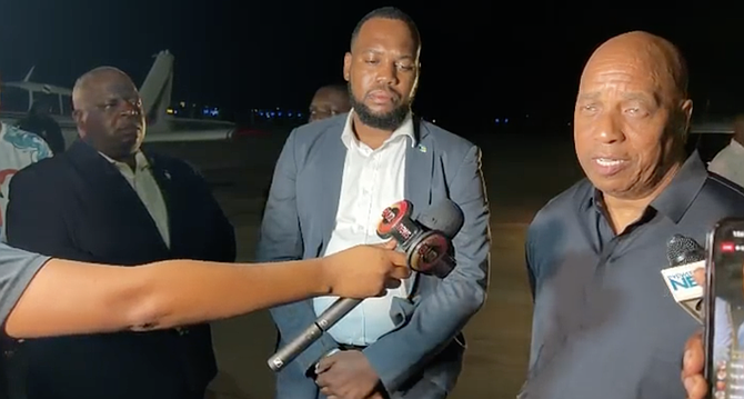Christian Council president Mario Moxey prays for the families of the people that died in the fatal North Andros plane crash as their bodies are received on the tarmac in Nassau on July 10, 2026.