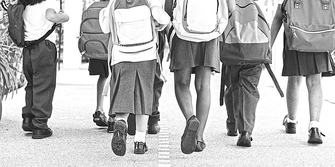 Stock image of children in uniform on their way to school.