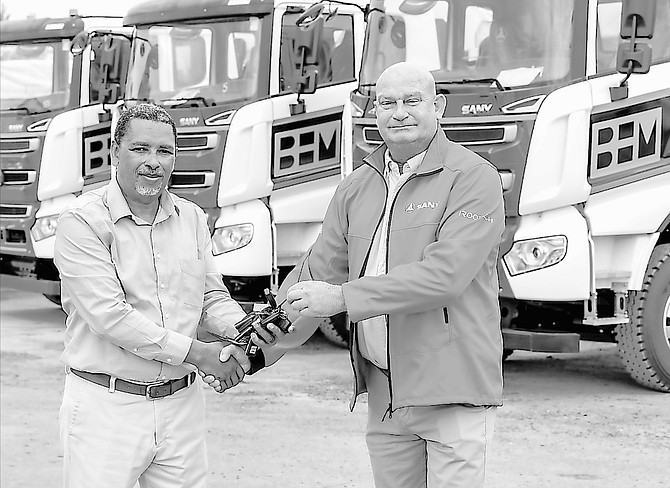 Stephen Litchfield, Equipment Services general manager, is pictured handing over the keys to Robert Garraway on seven dump trucks and one tractor head sold to BHM Company.