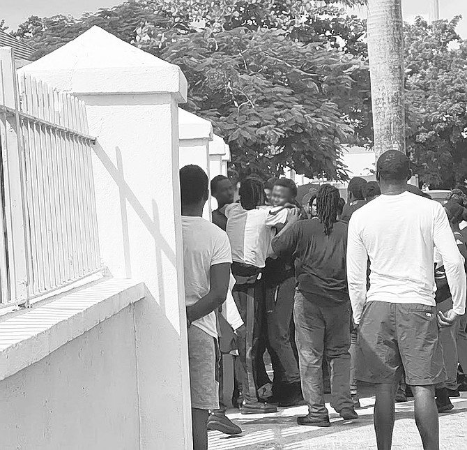 A POLICE officer is held back during an altercation on the campus of CC Sweeting.