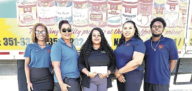 Jamaica Bahama Imports, in celebrating its 32nd anniversary in business, presented cash contributions to two local non-profit organisations. Norrisher Newman (second from left) of JBI presents a cheque donation on Thursday to Dudley and Katie Seide, of Reach Out Ministries.