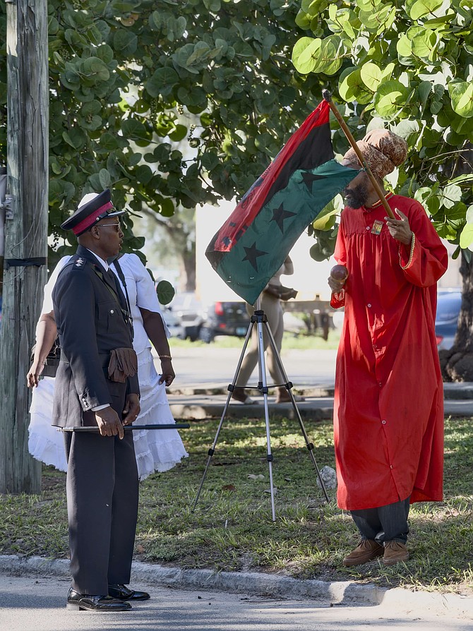 A POLICE officer speaks with a member of the Rastafarian group protesting during King Charles III’s visit yesterday.
Photos: Chappell Whyms Jr