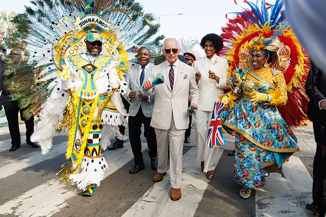KING Charles III got the Junkanoo fever as he dances down Bay Street with Bahamian colored cowbells at yesterday’s cultural festival at Parliament and Rawson Square. 
Photo: Tim Aylen/BIS